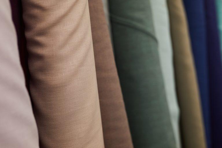 Close-up of different textile hanging in a row in the workshop or shop